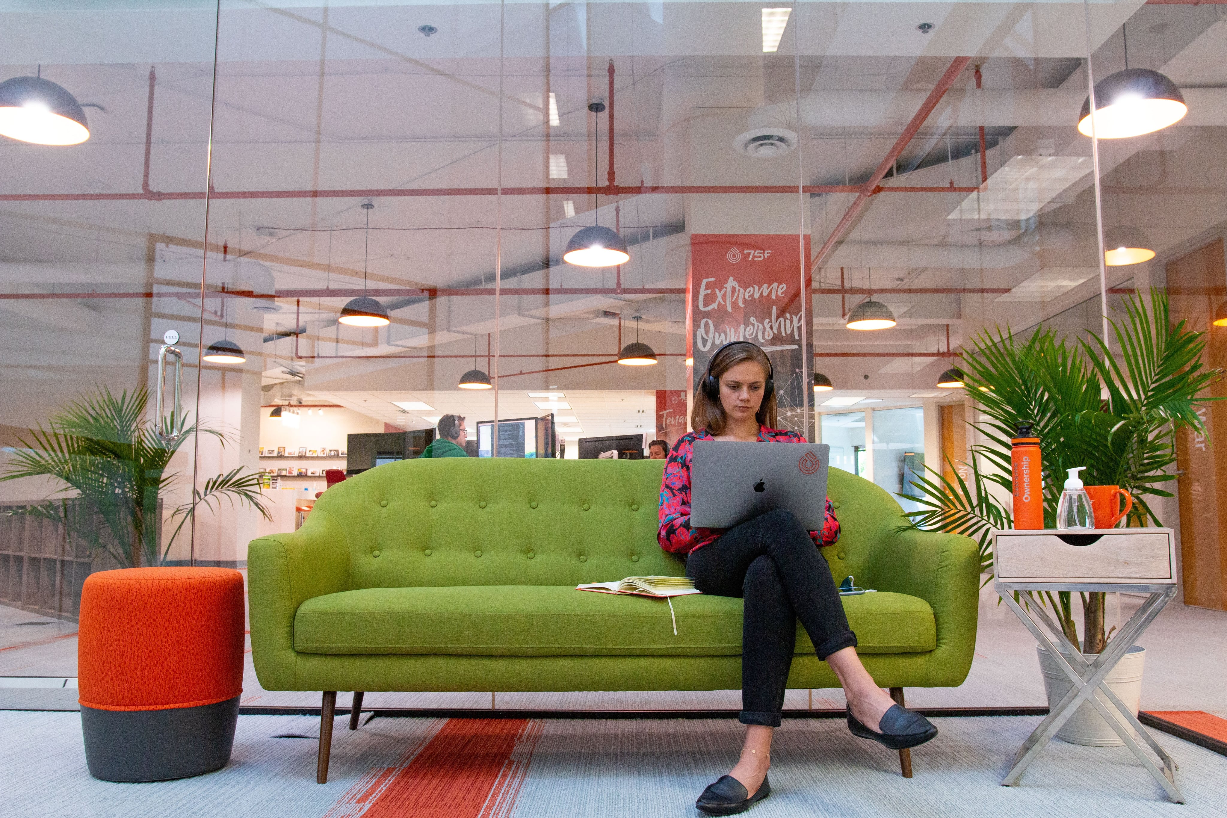 Female sat on office sofa on laptop
